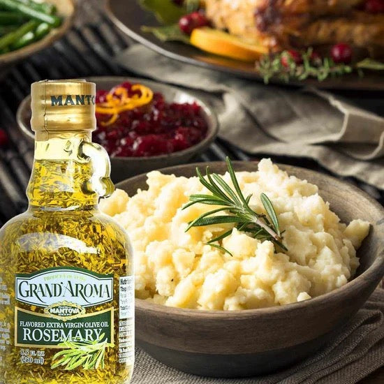 Bottle of Grand'Aroma Manto Rosemary olive oil with mashed potatoes and roasted vegetables in the background