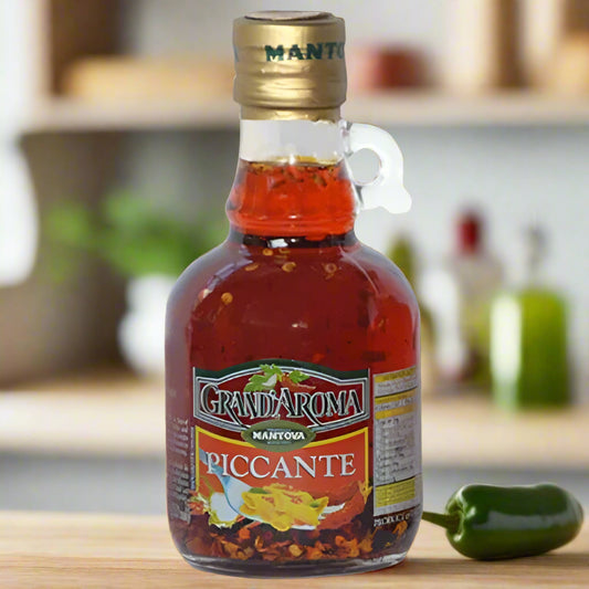 Bottle of Grand'Arroma Piccante sauce with a gold cap on a white background