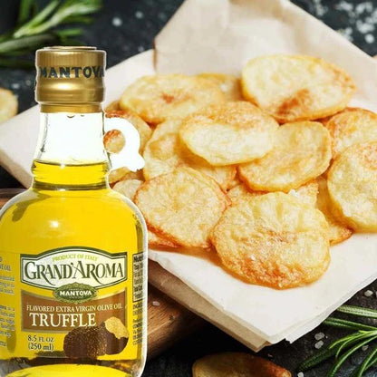 Bottle of Grand'Aroma Truffle olive oil with fried truffle chips on a wooden board.